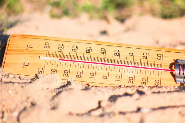 Kumdaki boş termometre, her yıl daha da ısınan hava konsepti.