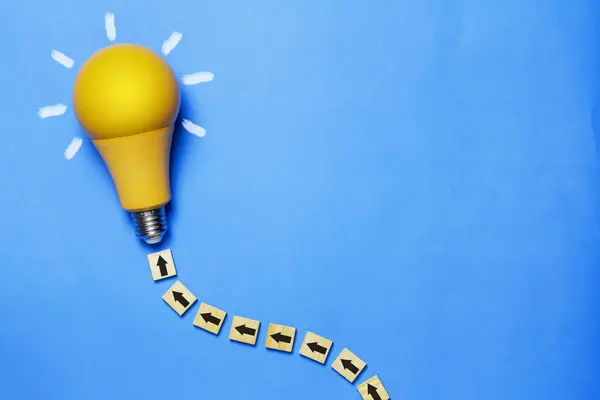 Kavram, fikirler, yaratıcılık ve ilham, mavi arkaplanda sarı ampul.