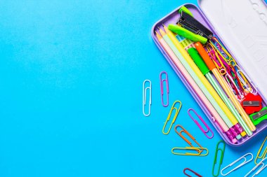 Mavi arka plandaki kutularda okul malzemeleri, eğitim öğrenme kavramı