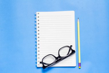 Mavi arkaplanda boş defter düzenlendi.