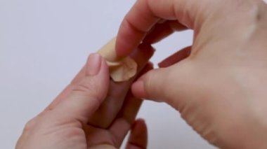 Bir adam yaradan yara bandını çıkarır. Yakın plan. Yaralar için ilk yardım. İlaçlar. İzole edilmiş arka plan. video.