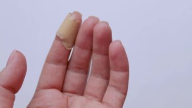 Yara bandından sonra elin parmağında. Yaralar için ilk yardım. Yakın plan. İzole edilmiş arka plan. Video.