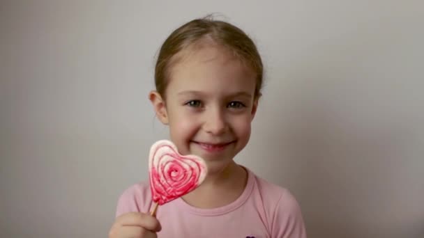 Happy Little Girl Holding Heart Shaped Lollipop Her Hands Delicious — Vídeo de Stock