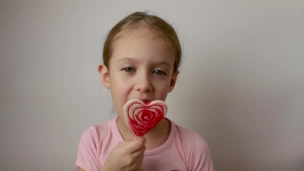 Happy Child Eats Delicious Lollipop Form Heart Valentines Day Isolated — стокове відео