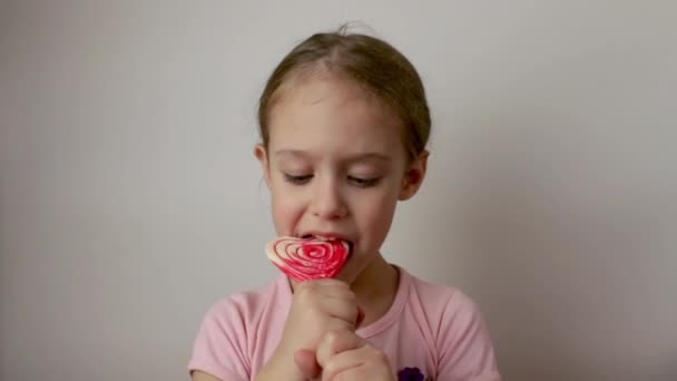 귀엽고 소녀가 모양의 롤리팝 디저트를 먹는다 발렌티누스의 맛있는 디저트 격리되어 — 비디오