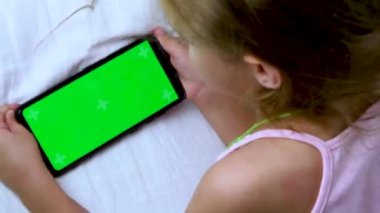 Çocuk yatakta bir cep telefonu izliyor. Krom yeşil ekran. Geceleri telefonda oyunlar oynanıyor. Kötü bir rüya. Video.