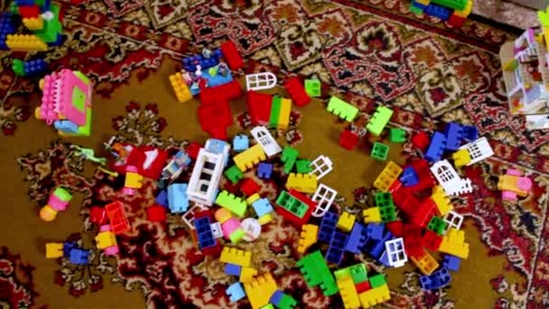 子供部屋の春の掃除 床の上に散乱マルチカラーコンストラクタ 保育園の混乱 — ストック動画