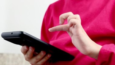 Elinde telefon tutan küçük bir kız. Eller yukarı. Telefondaki oyunlar. Beyaz arkaplan.
