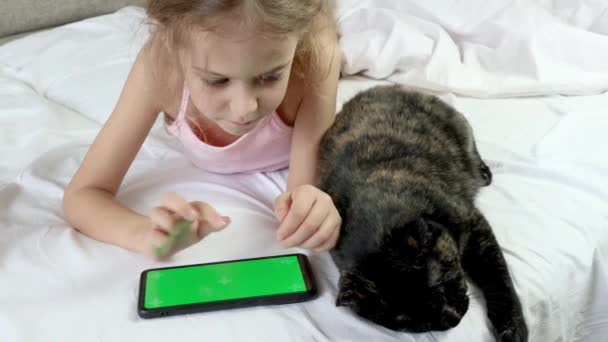 Bambino Guarda Uno Schermo Verde Del Telefono Gatto Nero Siede — Video Stock