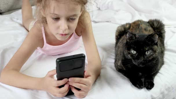 Niño Con Teléfonos Las Manos Cama Gato Negro Cerca Comunicación — Vídeos de Stock