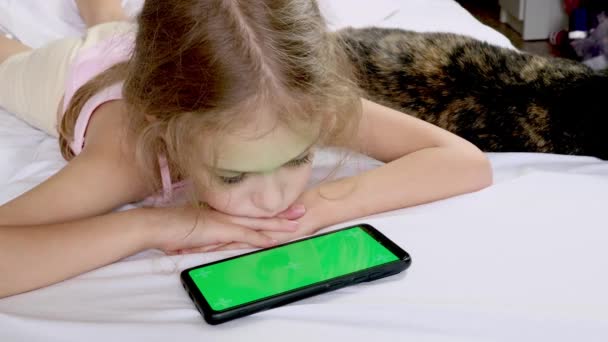 Bambino Guarda Uno Schermo Verde Del Telefono Letto Con Gatto — Video Stock