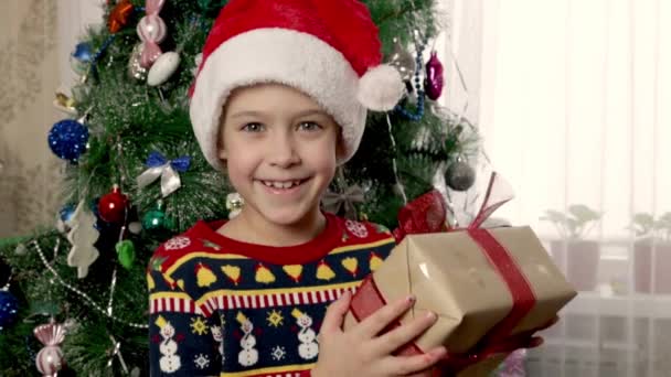 Una Niña Sonriente Con Sombrero Rojo Santa Claus Sacude Alegremente — Vídeos de Stock