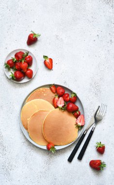 Beton arka planda çilekli leziz gözlemeler. Yukarıdan görüntüle.