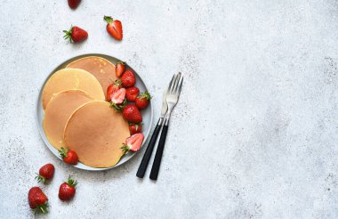 Beton arka planda çilekli leziz gözlemeler. Yukarıdan görüntüle.