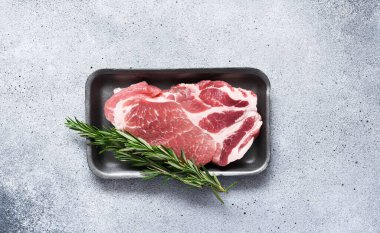 Beton arka planda çiğ biftek ve ahududu. Domuz eti. Rebay bifteği. Metin için boşluk ile