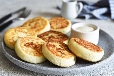 Beton tabakta ev yapımı peynirli kekler ve ekşi krema. Sos ve süzme peynir güveci..