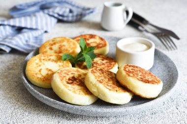 Beton tabakta ev yapımı peynirli kekler ve ekşi krema. Sos ve süzme peynir güveci..