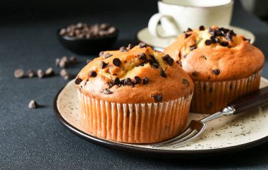 Koyu arkaplanda çikolata parçacıklı kekler.