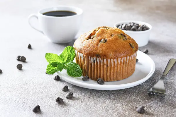 Muffin with chocolate chips and a cup of coffee. Morning and breakfast time.