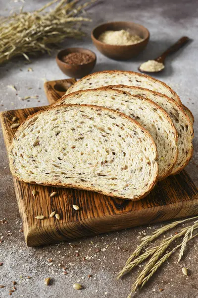 Whole grain bread on a wooden board on a brown background