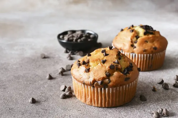 Muffin with chocolate chips on brown background. Sweet pastries.