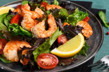 Yeşil arka planda karides ve domatesli salata..