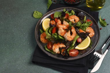 Yeşil zemin üzerinde karides ve domatesli salata ve metin için yer var..