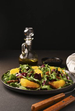Arugula, orange and pecan salad. Radicchio salad on brown background clipart