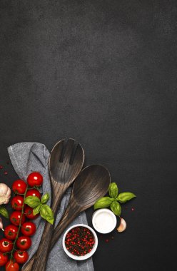 Spatula, mutfak havlusu ve siyah arka planda domatesler. Gıda arkaplanı