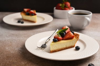 New York peynirli kek dilimi, böğürtlenli ve bir fincan kahveli.