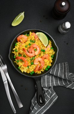 Karidesli pirinç ve koyu arkaplanda yeşil bezelye.