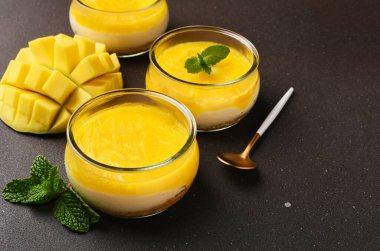 Kahverengi arka planda mangolu cheesecake.