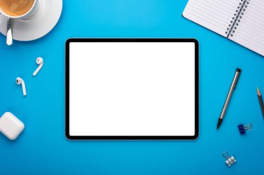 Mavi Masadaki Not Defteri ve Tablet Bilgisayarı ya da Yaratıcı çalışma alanı üzerine boş sayfa ya da ekranı olan bir şablon ya da şablon olarak dizilmiş arkaplan
