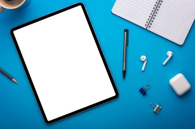 Mavi Masadaki Not Defteri ve Tablet Bilgisayarı ya da Yaratıcı çalışma alanı üzerine boş sayfa ya da ekranı olan bir şablon ya da şablon olarak dizilmiş arkaplan