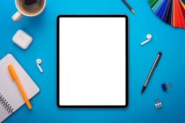 Mavi Masadaki Not Defteri ve Tablet Bilgisayarı ya da Yaratıcı çalışma alanı üzerine boş sayfa ya da ekranı olan bir şablon ya da şablon olarak dizilmiş arkaplan