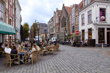 Ekim 2022. Leiden, Hollanda 'dan. Ortaçağ evleri olan tipik Hollanda caddesi, turistli kafeler