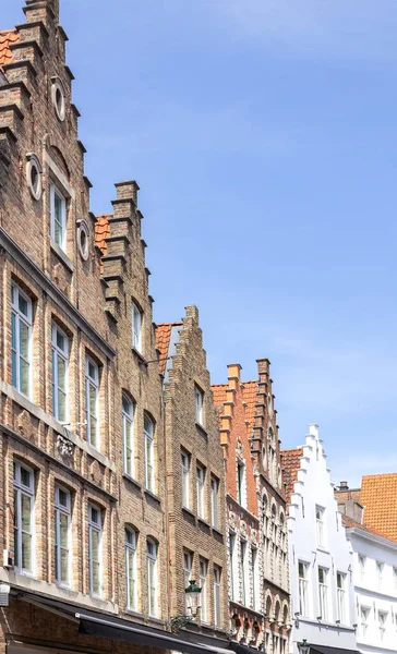 stock image Architecture of medieval brick houses in Bruges  in Belgium lined up against a blue sky.