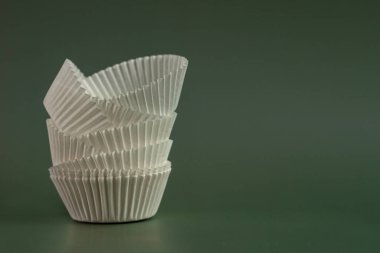 Yeşil arkaplandaki mafinleri kopyalamak için kullanılan beyaz kağıt formlarının bileşimi