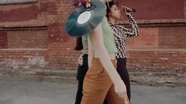 三个年轻的多民族女孩在散步时拥抱和跳舞 一群年轻的朋友在老城区的街上积极地聊天 老城区的嬉皮士高质量的4K镜头 — 图库视频影像