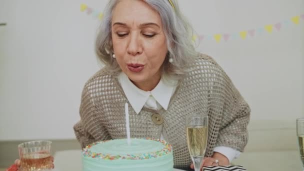 Eine Ältere Frau Bläst Bei Ihrem Geburtstagsessen Eine Kerze Auf lizenzfreies Stockvideo