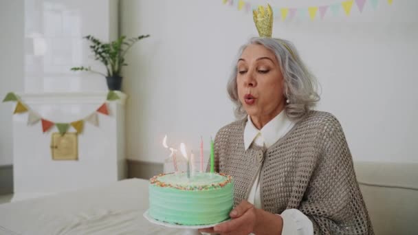 Eine Ältere Frau Bläst Bei Ihrem Geburtstagsessen Eine Kerze Auf Lizenzfreies Stock-Filmmaterial