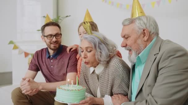 Eine Ältere Frau Bläst Beim Geburtstagsessen Mit Ihrer Familie Eine Stockvideo