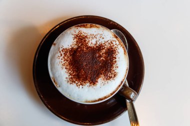 Masada bir fincan cappuccino kahve. Üst görünüm