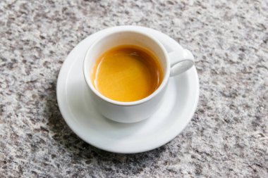 Gri taş bir masada bir fincan kahve.