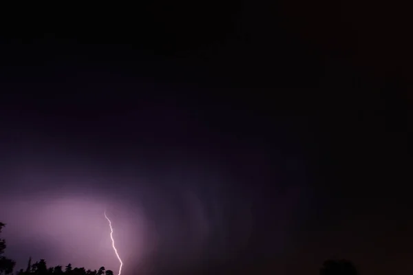 夜の暗い雨の雲の下で嵐の空に雷放電 — ストック写真