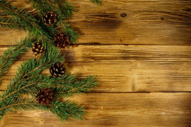 Noel kompozisyonu köknar ağacı dalları ve tahta arka planda koniler. Üst görünüm, alanı kopyala