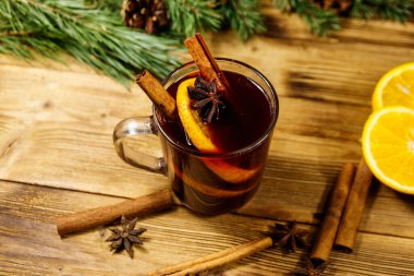 Noel şarabı baharatlar ve köknar ağacı dalları ve kozalaklar ahşap masada.