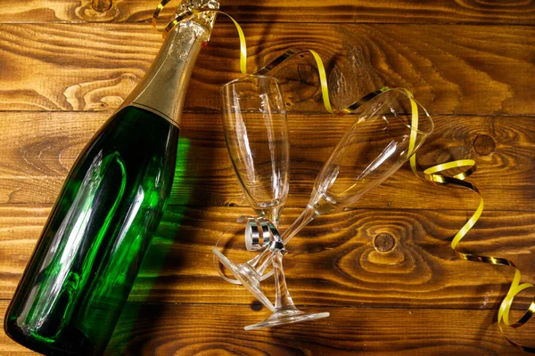 Láhev Šampaňského Dvě Prázdné Sklenice Šampaňského Dřevěném Pozadí Horní Pohled — Stock fotografie