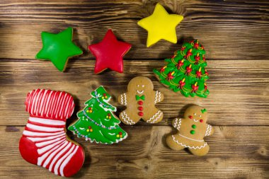 Noel ağacı şeklinde lezzetli Noel kurabiyeleri, zencefilli kurabiye adam, yıldız ve ahşap masada Noel çorabı. Üst görünüm