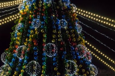 Geceleyin çok renkli ışıklarla süslenmiş Noel ağacı